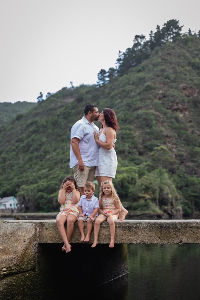 Family on a bridge, parents kissing. Family Photoshoot. JDL Photography. Photographer based Johannesburg, Pretoria, Gauteng, South Africa